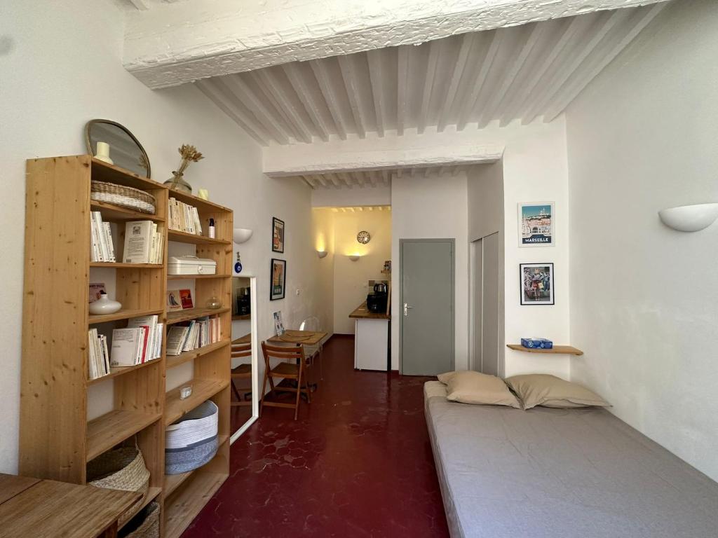 une chambre avec un lit et une étagère dans l'établissement Chez Victor - Studio tout équipé - centre ville historique - Proche Mairie et Forum des Cardeurs, à Aix-en-Provence