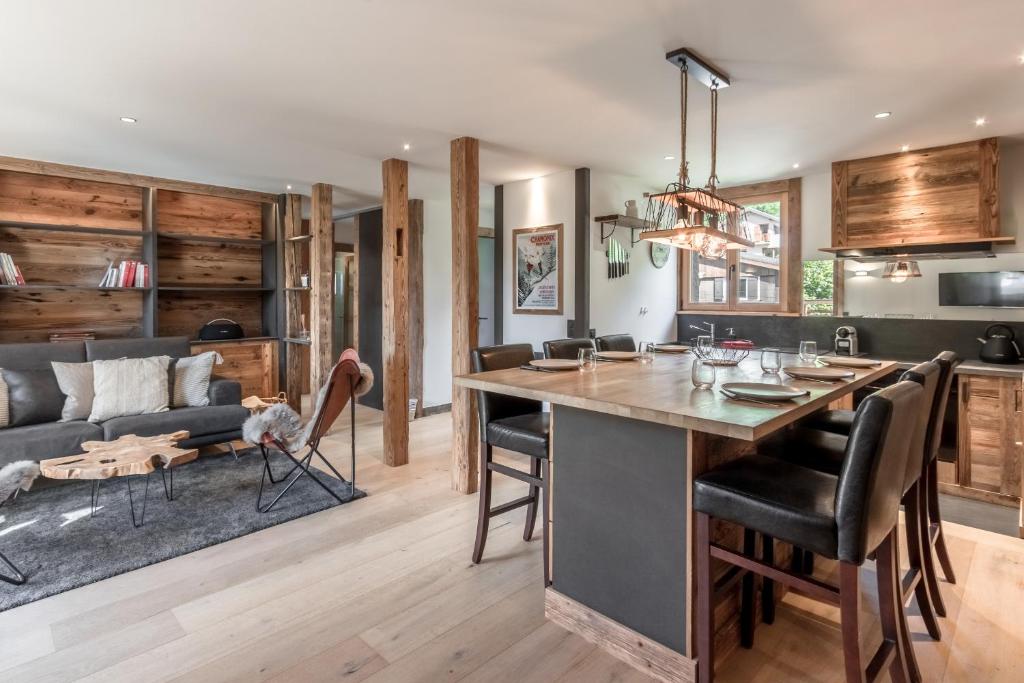 Il comprend une cuisine et un salon avec une grande table et des chaises. dans l'établissement Le Chardonnet, à Sallanches