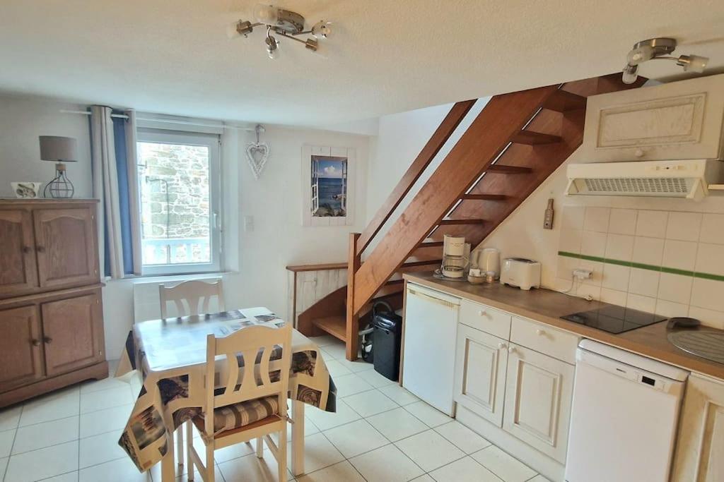 une cuisine avec une table et un escalier. dans l'établissement Deux pièces centre historique, à Vannes