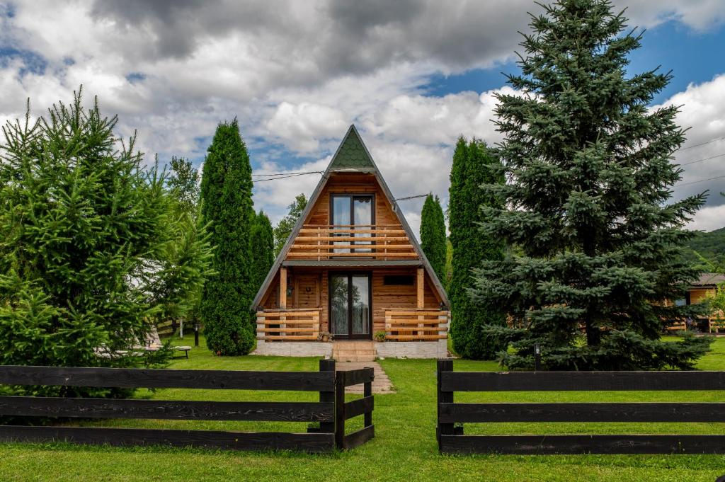 ヴェリカ・プラナにあるChalet Velebitska Kućaの塀と木を持つ丸太小屋
