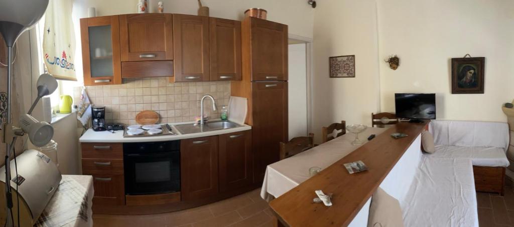 a kitchen with wooden cabinets and a counter top at Elsa Apartment in Aegina Town