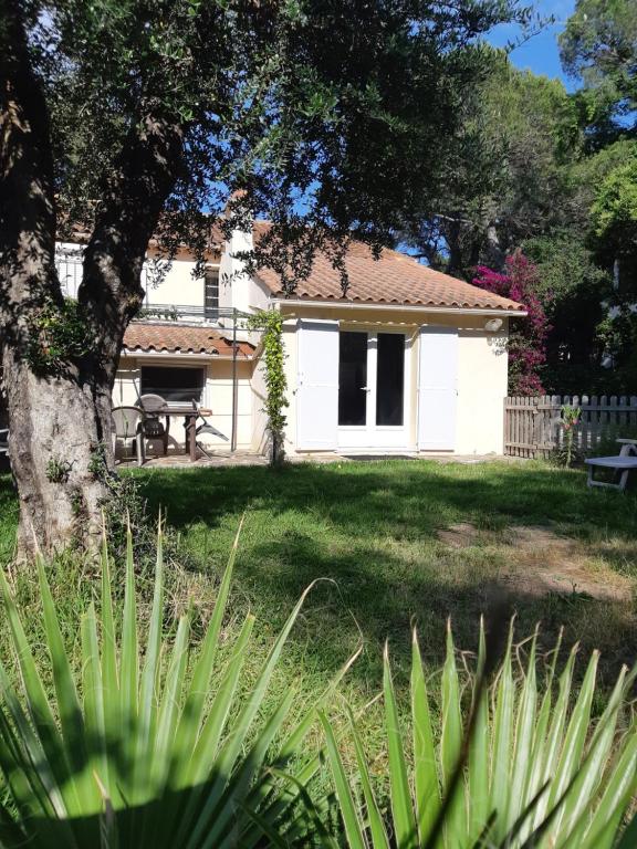 une maison blanche avec une table de pique-nique dans une cour dans l'établissement Appartement en rez de villa, à Saint-Raphaël