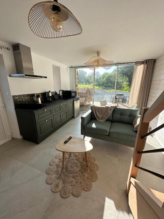 un salon avec un canapé et une table dans l'établissement Les Marais Blancs à Picauville, à Picauville