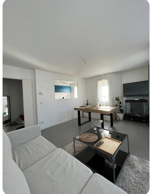 un salon avec un canapé et une table dans l'établissement Duplex spacieux-30 min de Paris-15 min Disneyland, à Villiers-sur-Marne