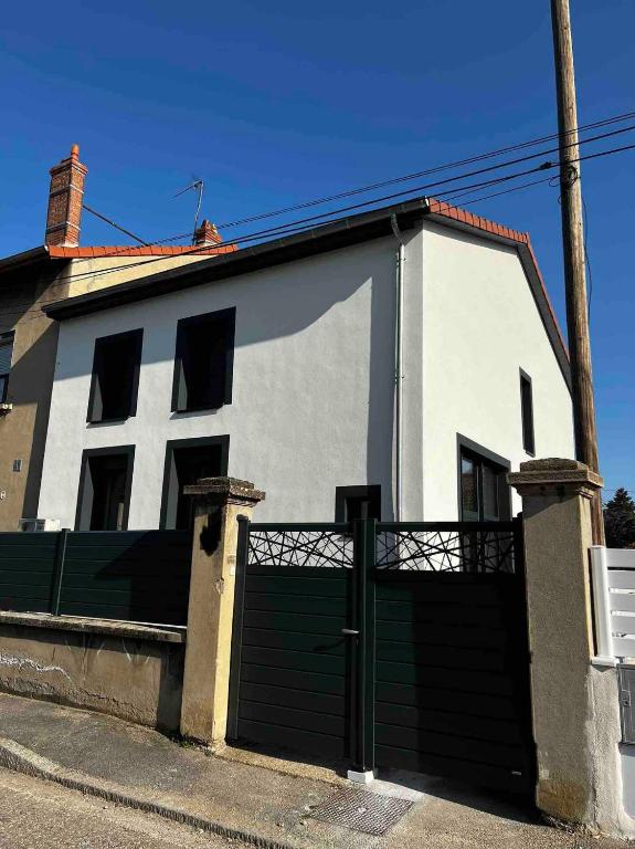 une maison blanche avec une porte en face dans l'établissement Agréable maison rénovée, en ville et au calme !, à Lyon