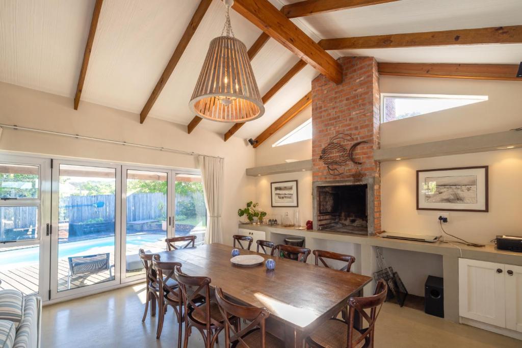 a dining room with a wooden table and chairs at Delightfully Casual & Spacious in Cape St Francis