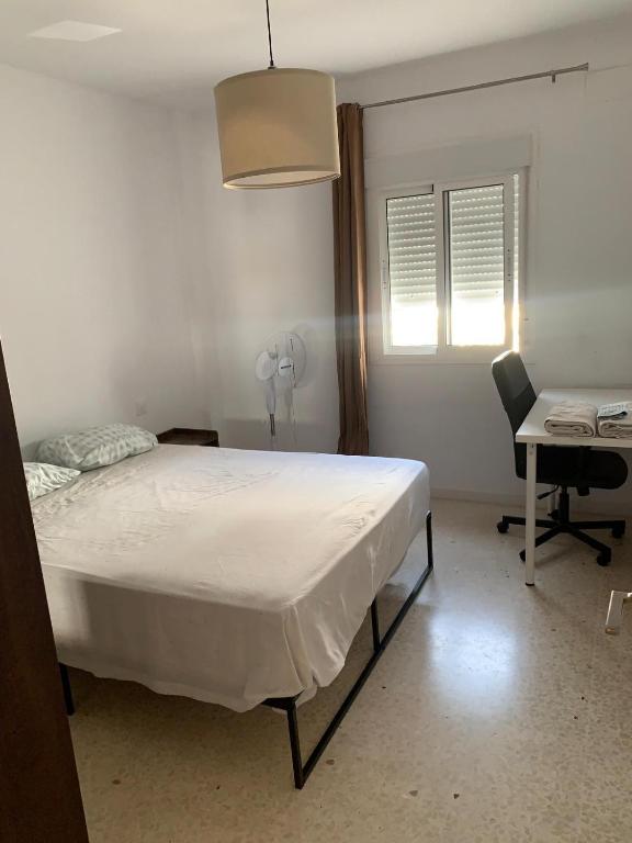 sypialnia z łóżkiem, biurkiem i krzesłem w obiekcie Casa Amapola - Costa Bahía de Cádiz w mieście Puerto Real