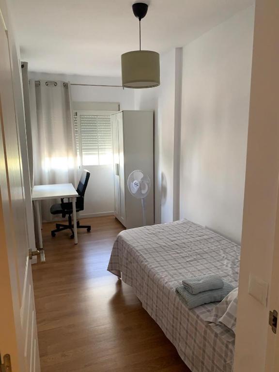 biała sypialnia z łóżkiem i biurkiem w obiekcie Casa Amapola - Costa Bahía de Cádiz w mieście Puerto Real
