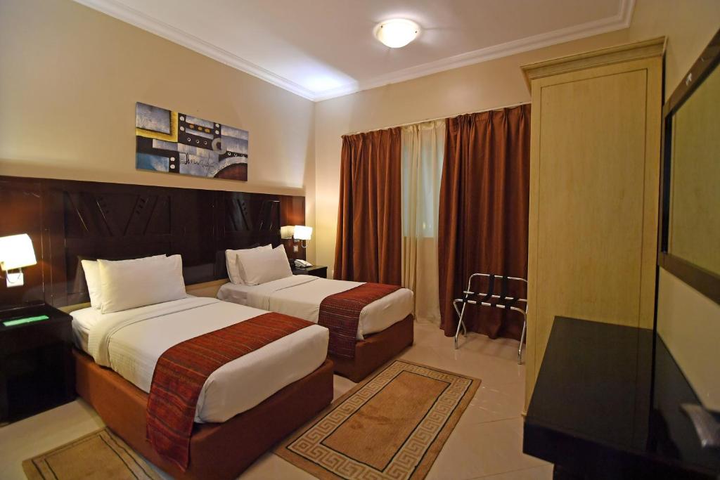 Postel nebo postele na pokoji v ubytování Emirates Stars Hotel Apartments Sharjah