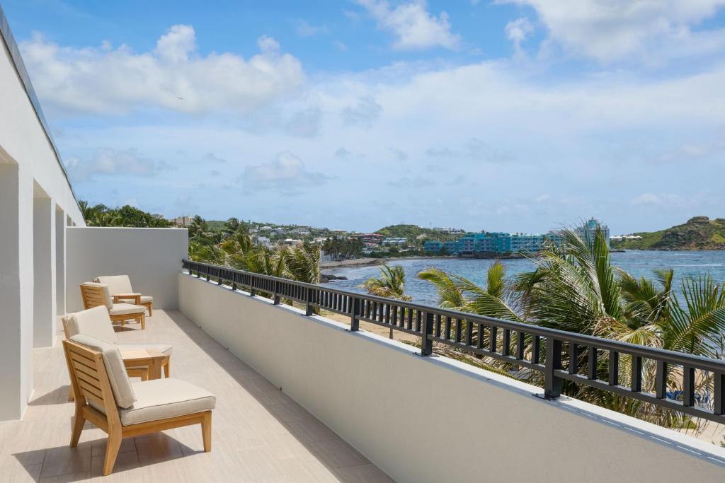 a balcony with chairs and a view of the ocean at JW Marriott St Maarten Beach Resort & Spa in Dawn Beach