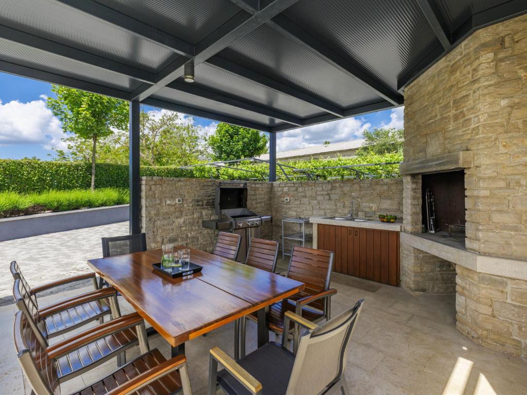 - patio z drewnianym stołem i krzesłami w obiekcie Villa Luna Rossa by Interhome w mieście Sveti Petar u Šumi