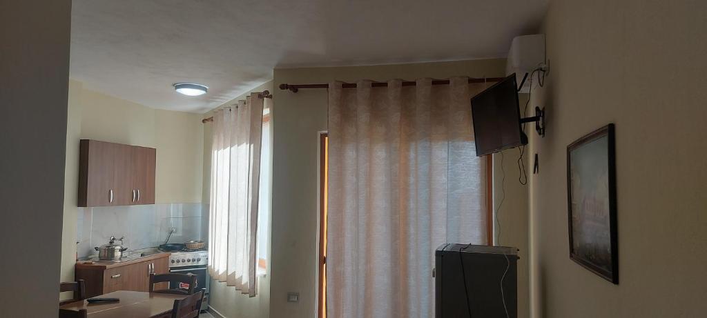 a kitchen with a window with a curtain and a sink at Rigandi in Durrës