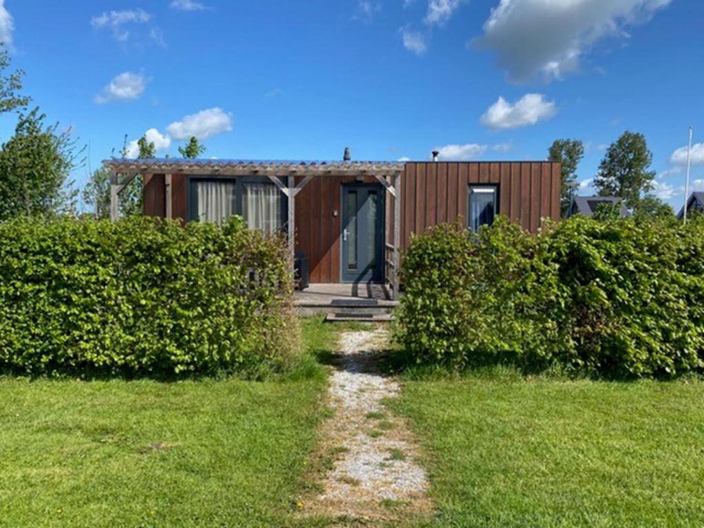 a small house with a pathway leading to it at Holiday Home 4-persoons Doutzen by Interhome in De Veenhoop