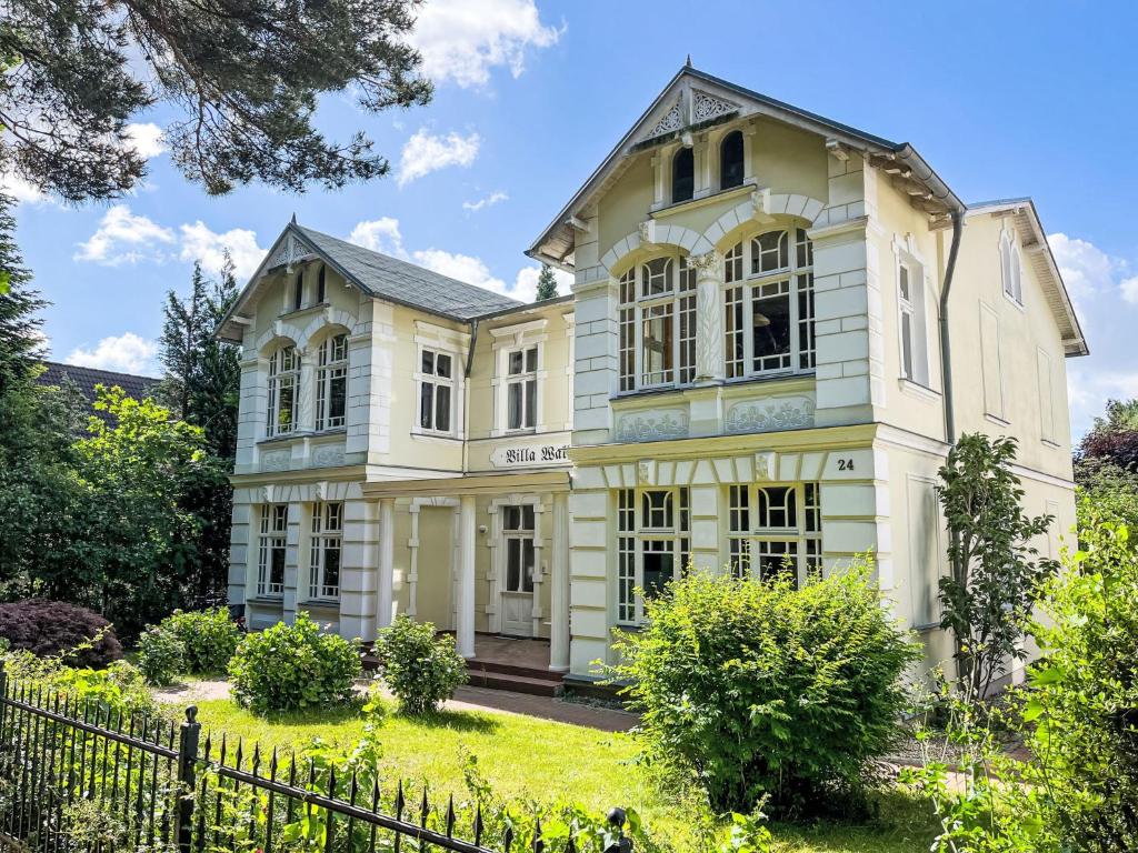 ein großes weißes Haus mit einem Zaun in der Unterkunft Apartment Wildrose by Interhome in Zempin