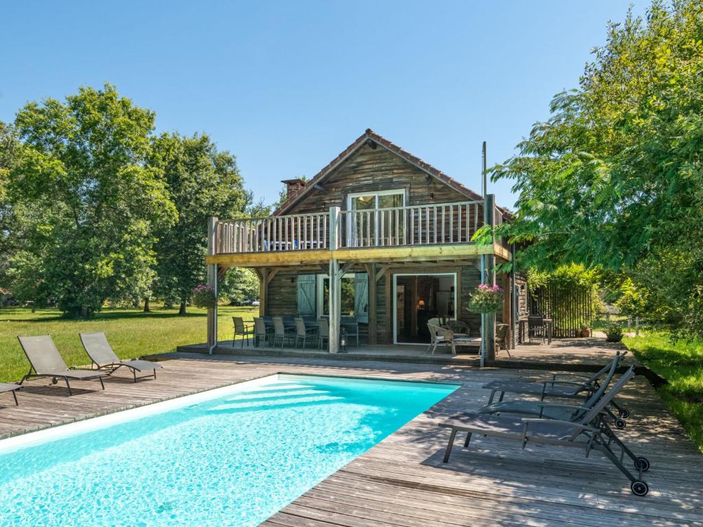 a house with a swimming pool in front of a house at Holiday Home La Grange du Belon by Interhome in Saint-Julien-en-Born