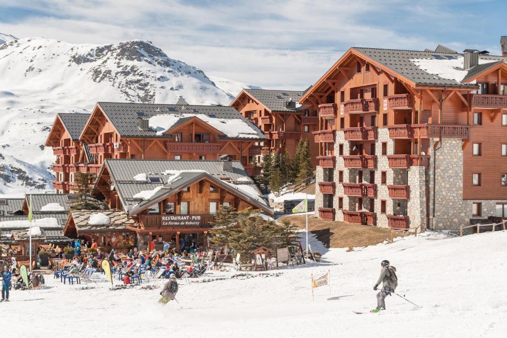un grupo de personas esquiando en la nieve frente a un lodge en travelski home classic - Résidence Boedette, en Les Menuires