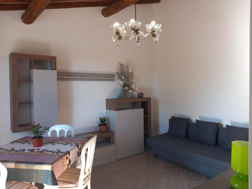 a living room with a table and a blue couch at Mary's House in Guardistallo