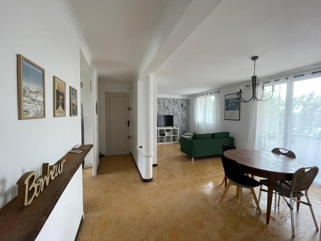 - un salon avec une table et un canapé vert dans l'établissement Appartement de Florent, à Arles