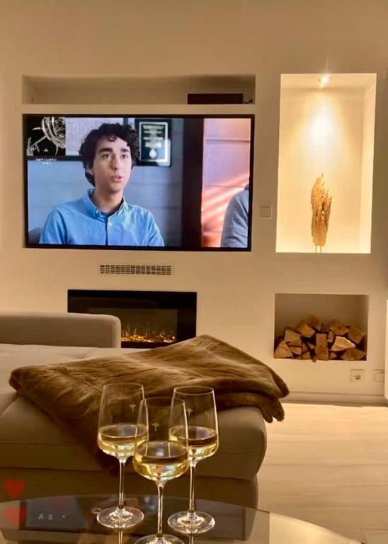 two wine glasses on a table in a living room with a tv at Ferienwohnung an der Wildenburg in Kempfeld