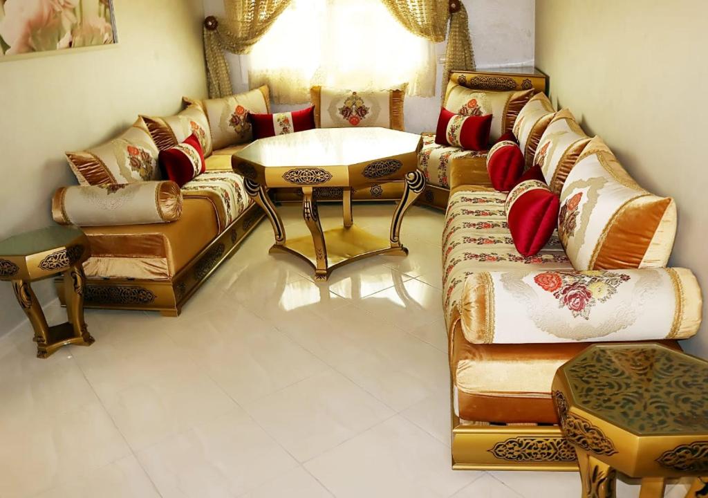 een woonkamer met een bank en een tafel bij Résidence riad al andalos in Nador
