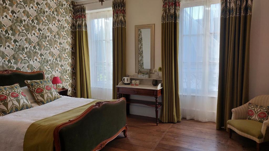 une chambre avec un lit, une chaise et un miroir dans l'établissement B&B Maison de Ville Lubersac, à Lubersac