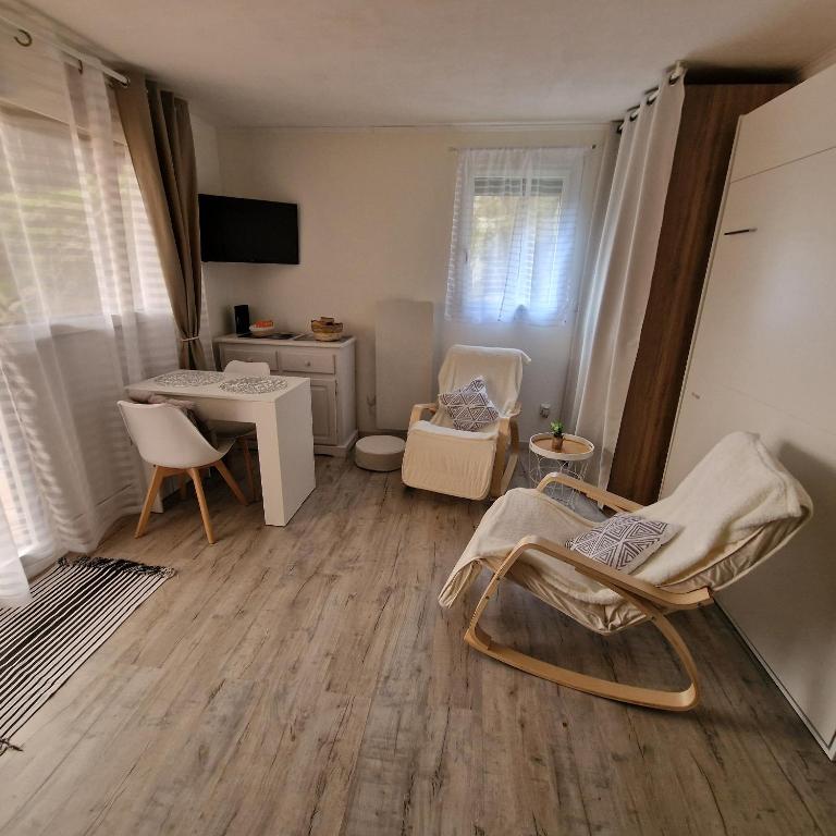 Cette chambre dispose de chaises, d'une table et d'un bureau. dans l'établissement Studio 2 pers, rez-de-chaussée, grande terrasse plein sud, à Font-Romeu-Odeillo-Via
