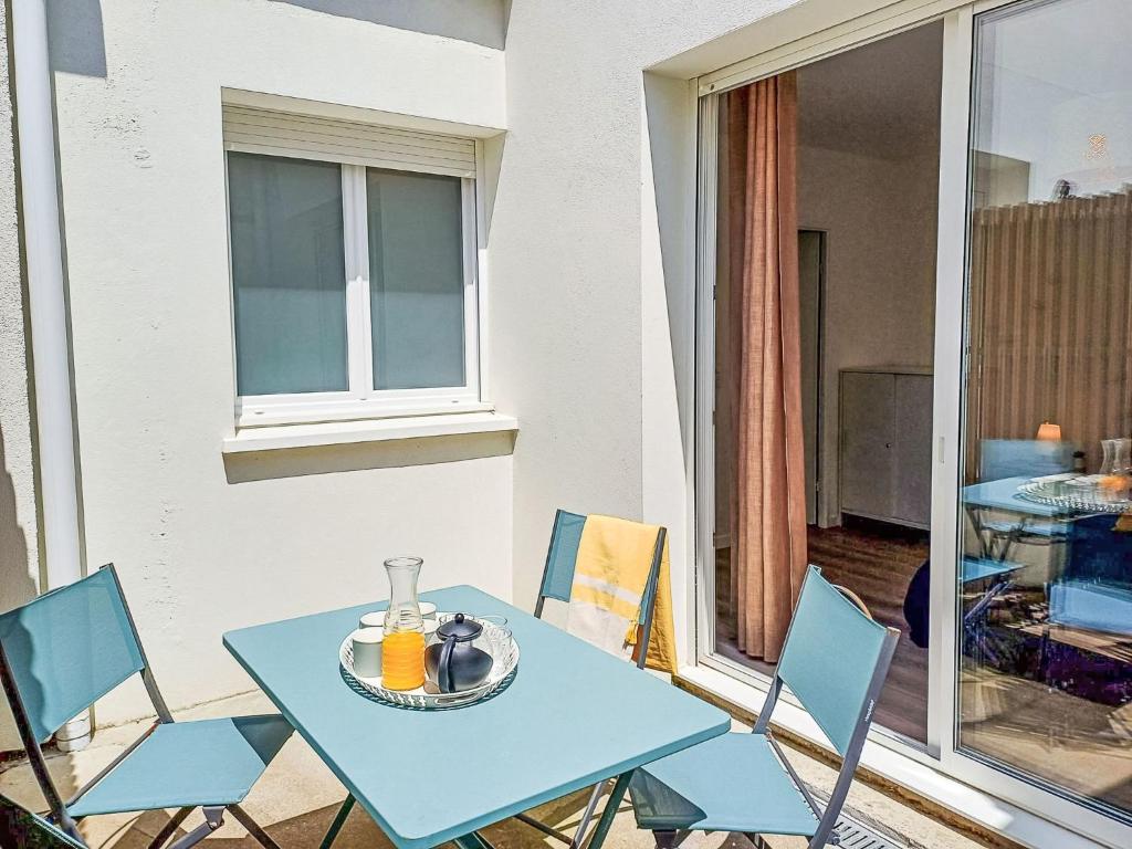 une table bleue et des chaises sur un balcon dans l'établissement Apartment Cap Océan-6 by Interhome, à Capbreton