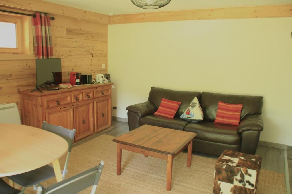 un salon avec un canapé en cuir et une table dans l'établissement Ours Blanc ORB NATURE & QUIET 4 Pers, à Châtel