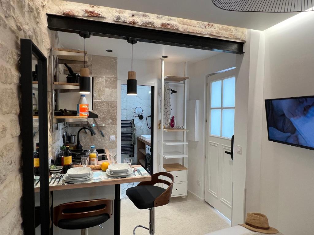 - une cuisine avec une table et une télévision dans la chambre dans l'établissement Studios Clouet-Paris Centre- XVe!, à Paris