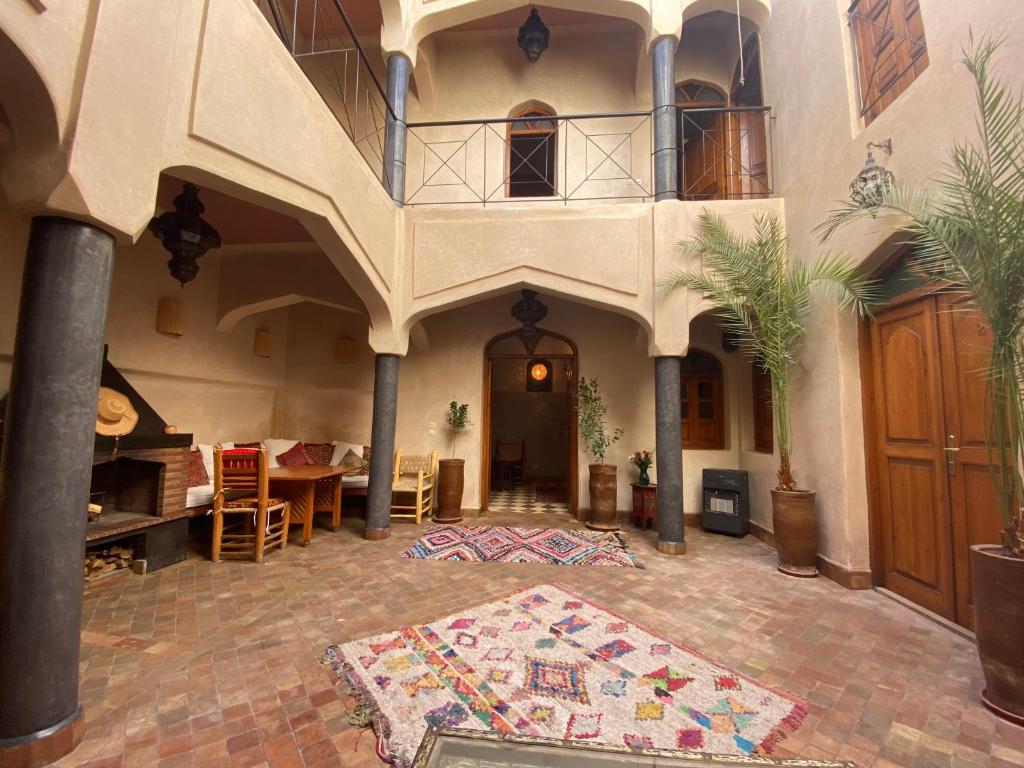un grand salon avec un escalier et un tapis dans l'établissement Riad Sabah, à Marrakech