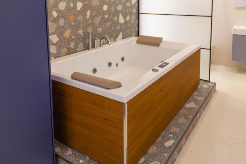 a bath tub in a bathroom with a wooden cabinet at Boca Luxury Rooms in Tarquinia