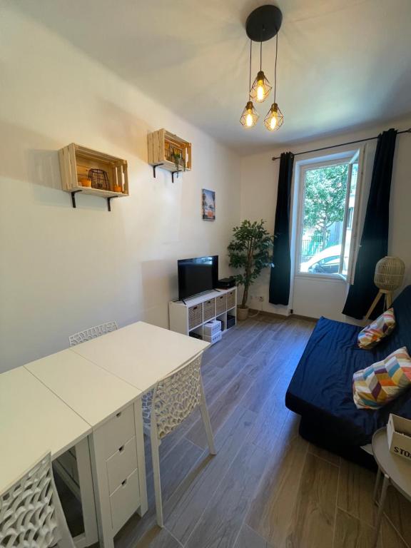un salon avec une table et un canapé dans l'établissement Appartement 4 personnes à 2mn des plages, à Toulon