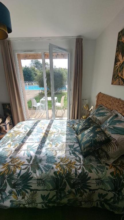 - une chambre avec un lit et une vue sur une terrasse dans l'établissement Joli studio piscine et parking 3km Honfleur, à Équemauville