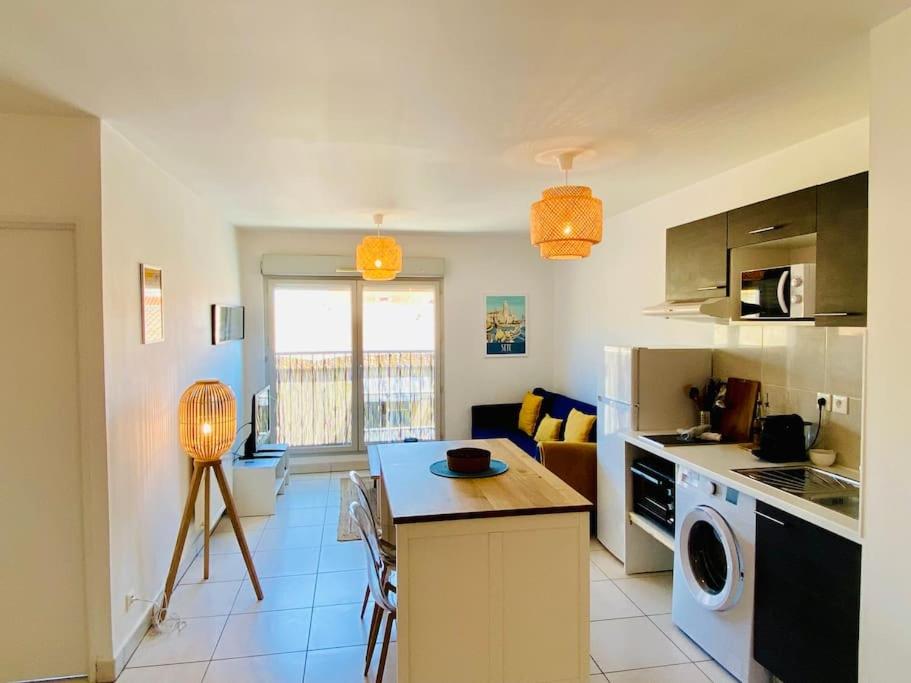 a kitchen with a table and a counter top at ''Loulou'' T1 moderne et lumineux, centre ville, wifi, parking in Sète