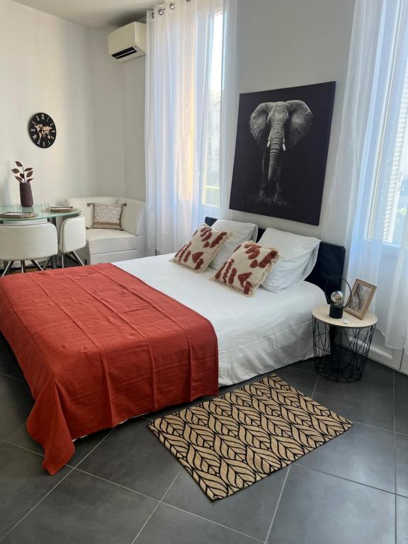 - une chambre avec un lit et une photo d'éléphant sur le mur dans l'établissement Cosy Cannes Studio, à Cannes