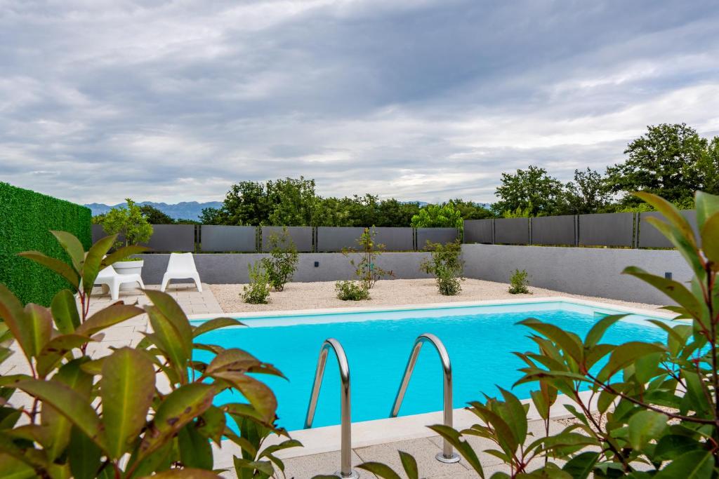 a swimming pool in a backyard with a fence at Holiday home Olive Hill in Brig