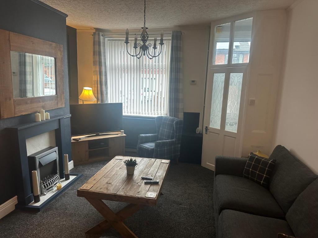 Una sala de estar con un sofá y una mesa de café. en Family house, en Oldham