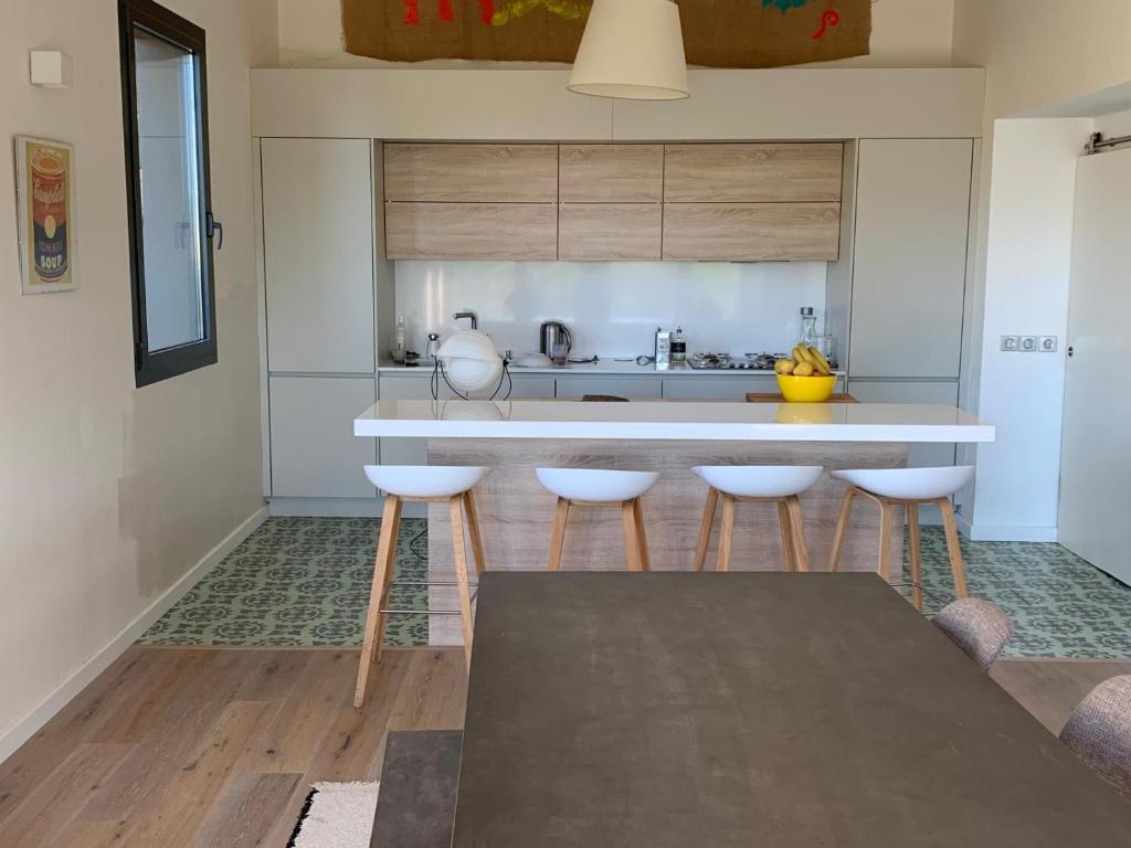 une cuisine avec un comptoir et quatre tabourets dans l'établissement Villa Sainte Victoire, au Tholonet