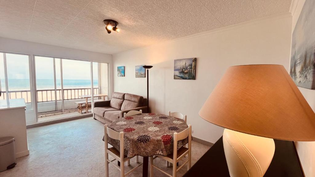 un salon avec une table et un canapé dans l'établissement Appartement sable et océan, à Saint-Jean-de-Monts