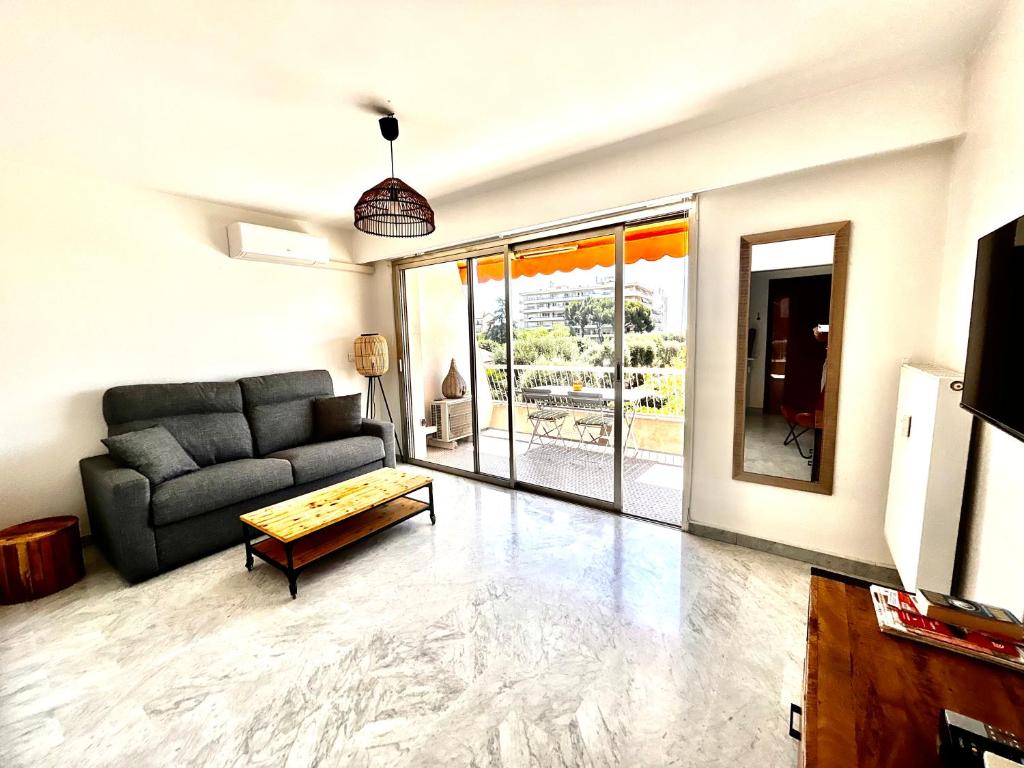 un salon avec un canapé et une table dans l'établissement Superbe studio, 200 m de la mer, climatisé avec terrasse et parking privé, à Cagnes-sur-Mer