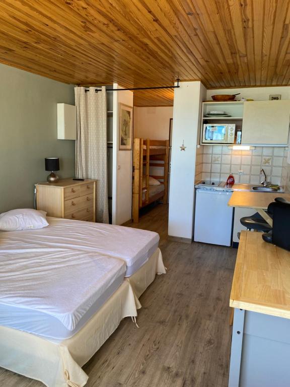 une chambre avec un grand lit et une cuisine dans l'établissement Studio cabine vue mer saint pierre la mer, à Fleury