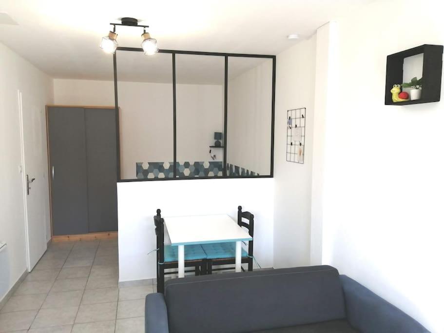 - un salon avec une table et un miroir dans l'établissement Studio au coeur de la Vendée, à Thorigny