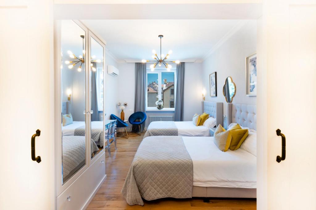 una camera d'albergo con due letti e uno specchio di Sofia Royal Retreat a Sofia
