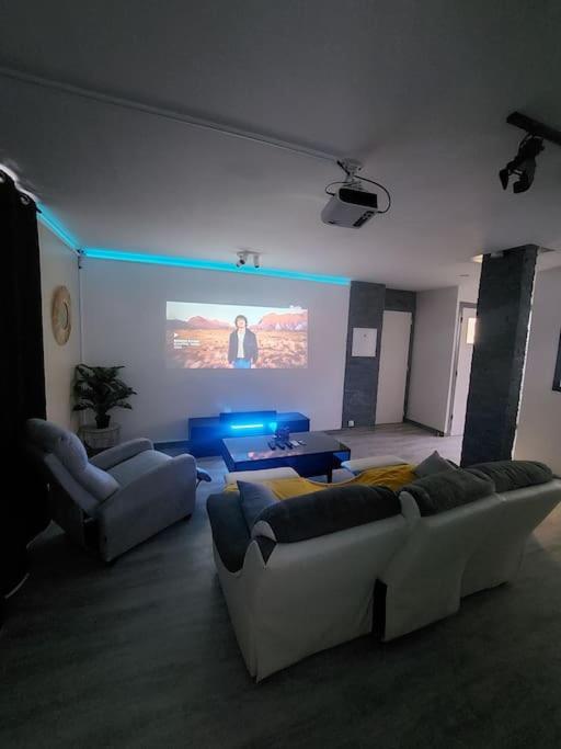 - un salon avec deux canapés et un écran de projection dans l'établissement Cinéma room 2 chambres séparées, à Morlaix