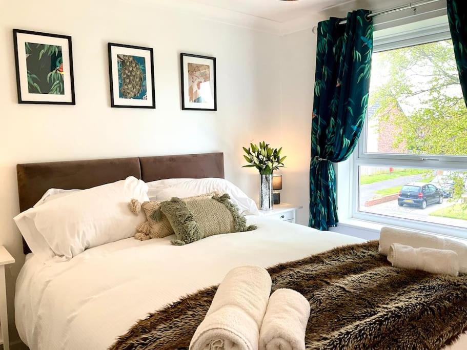 a bedroom with a large white bed with a window at Morpeth Apartment in Morpeth