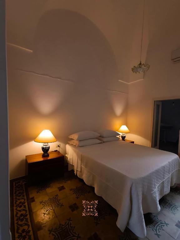 a bedroom with a white bed and two lamps at Domus Donata in Galatone