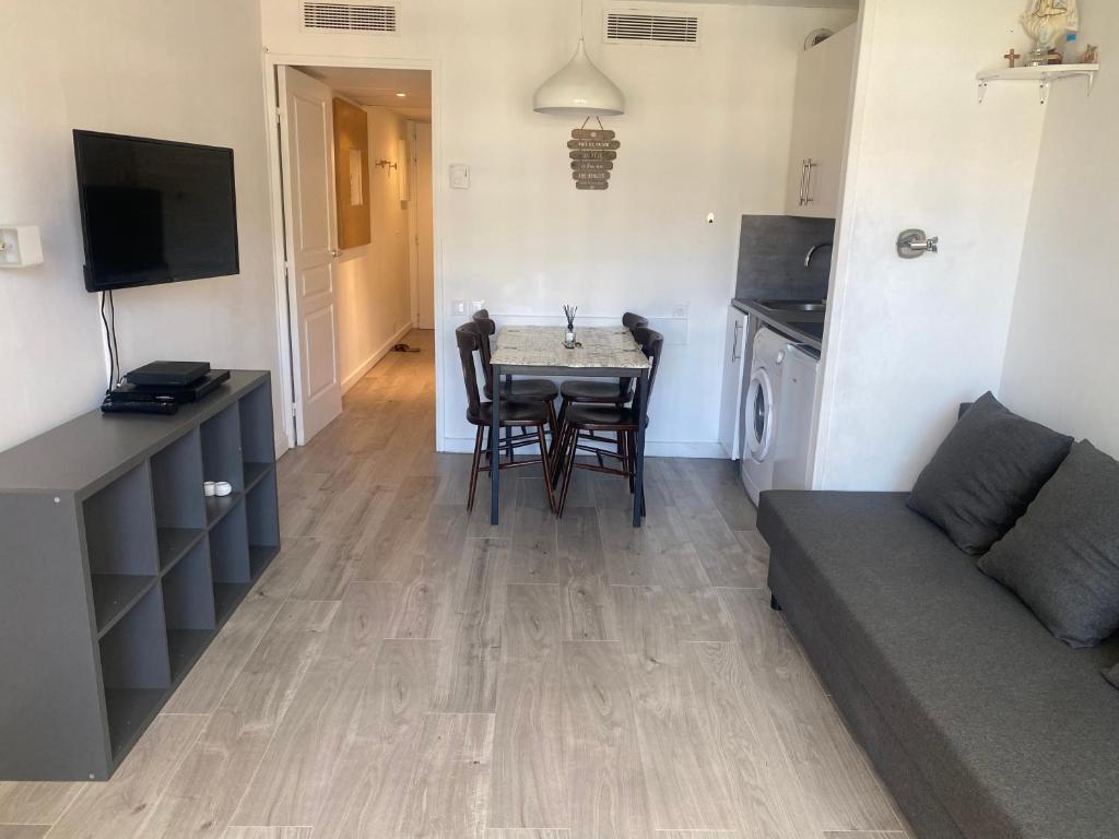 un salon avec une table et un canapé dans l'établissement Appart. Piscine 4 pers. à 150m Plage, à Cannes