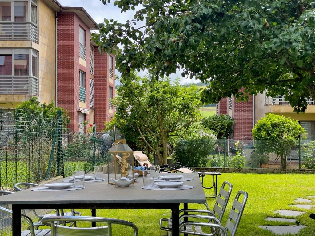 a table and chairs in a yard with a building at La Ensenada de Meruelo - 2805 in San Miguel de Meruelo