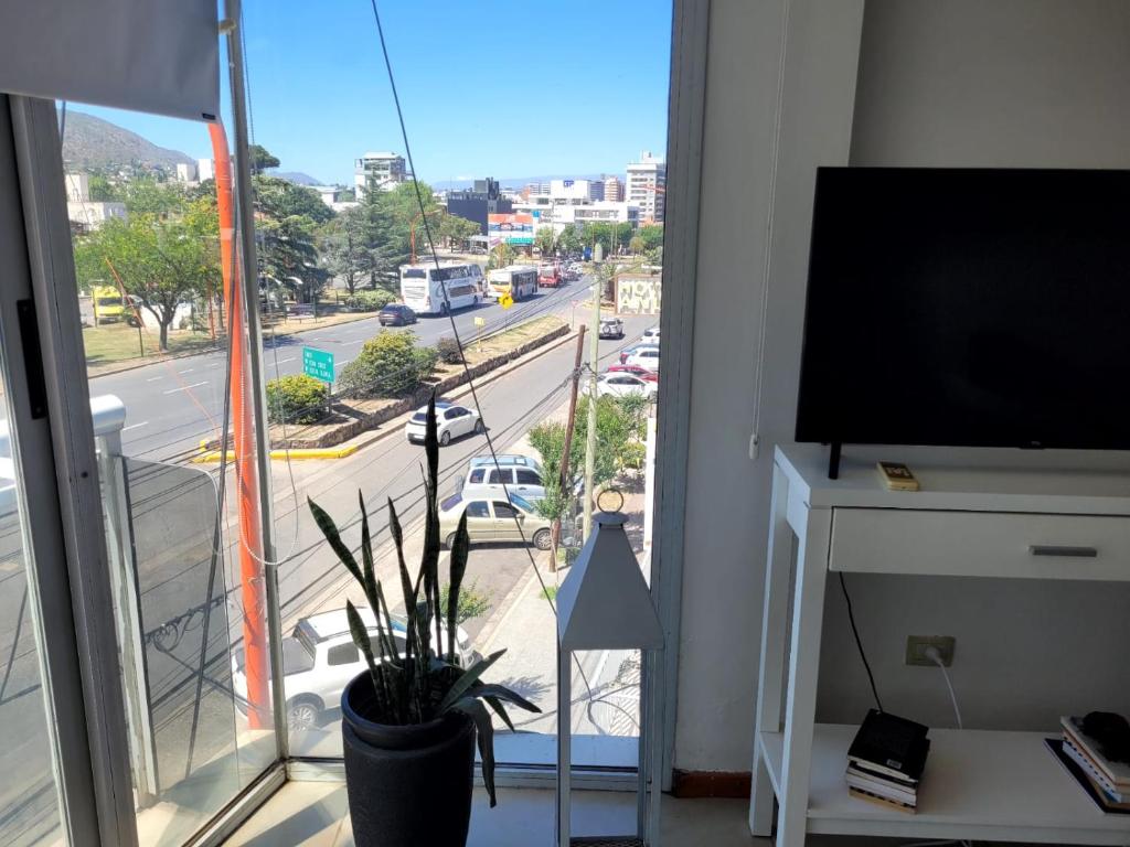 a living room with a flat screen tv and a window at Carilo in Villa Carlos Paz