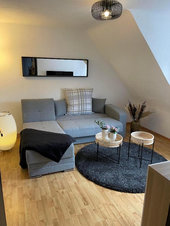 a living room with a blue couch and two tables at Ferienwohnung am Kelterplatz in Löwenstein